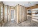 An unfinished room featuring exposed framing, cinder block walls, and doorway to the backyard at 94 Devon Dr, Clearwater Beach, FL 33767