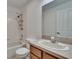 Bathroom featuring vanity with drawers, sink, commode, mirror, and shower/tub with tile surround at 9506 Harpender Way, Tampa, FL 33626
