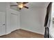 Cozy bedroom featuring a ceiling fan, wood-look flooring, closet with white bifold doors, and gray curtains at 9506 Harpender Way, Tampa, FL 33626