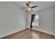 Bright bedroom featuring sleek wood-look flooring, a ceiling fan, and a window with gray curtains at 9506 Harpender Way, Tampa, FL 33626