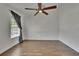 Bright, empty bedroom features wood-look tile, a ceiling fan, and natural light from a large window at 9506 Harpender Way, Tampa, FL 33626
