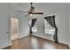 Bedroom with wood-look flooring, a ceiling fan, and two windows with gray curtains at 9506 Harpender Way, Tampa, FL 33626