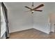 Bright, empty bedroom features wood-look tile, a ceiling fan, and natural light from a large window at 9506 Harpender Way, Tampa, FL 33626