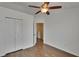 Bedroom featuring wood-look flooring, a ceiling fan, and an open door to another room at 9506 Harpender Way, Tampa, FL 33626