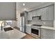 Stylish kitchen with stainless steel appliances, gray cabinets, and subway tile backsplash at 9506 Harpender Way, Tampa, FL 33626