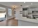 Bright dining area with modern light fixture, open to the kitchen with stainless appliances at 9506 Harpender Way, Tampa, FL 33626