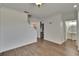 Open living space with wood-look tile flooring and neutral walls, transitioning to the kitchen at 9506 Harpender Way, Tampa, FL 33626