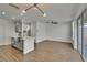 Open-concept living room and kitchen with modern lighting, wood floors, and access to the outdoor patio at 9506 Harpender Way, Tampa, FL 33626