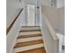 Well-lit staircase with wood steps and white risers leads to the upper level at 9506 Harpender Way, Tampa, FL 33626