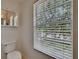 Toilet next to a large, bright window with an updated medicine cabinet at 9506 Harpender Way, Tampa, FL 33626