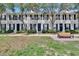 Exterior view of townhomes with landscaped lawns and a welcoming bench at 9506 Harpender Way, Tampa, FL 33626
