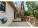 Relax on the wooden back deck that includes stairs, railing, and a sliding glass door into the home at 9812 N Pawnee Ave, Tampa, FL 33617