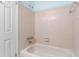 Bathroom showcasing a bathtub with neutral tile surround and hardware, accompanied by a standard shower head at 9812 N Pawnee Ave, Tampa, FL 33617