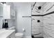 Updated bathroom showcasing white marble-look shower tiles, modern fixtures, and a sleek vanity at 9812 N Pawnee Ave, Tampa, FL 33617