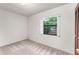 Cozy bedroom with carpet, a window offering a view, and closet doors for storage at 9812 N Pawnee Ave, Tampa, FL 33617