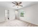Bright bedroom features ceiling fan, neutral carpet, and ensuite bathroom with tiled shower at 9812 N Pawnee Ave, Tampa, FL 33617