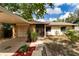 Well-maintained home with covered carport, stone accents, and lush landscaping at 9812 N Pawnee Ave, Tampa, FL 33617
