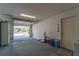 Open garage space featuring a standard garage door, side entrance, and exposed ceiling at 9812 N Pawnee Ave, Tampa, FL 33617