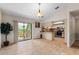 Open floorplan kitchen boasts stainless steel appliances, breakfast bar, and sliding door access to the deck at 9812 N Pawnee Ave, Tampa, FL 33617