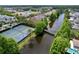 Beautiful aerial view showcasing tennis courts and the community's waterway surrounded by lush trees at 10309 Marchmont Ct, Tampa, FL 33626
