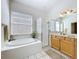 Bathroom featuring a separate shower and tub, and light wood cabinets at 10309 Marchmont Ct, Tampa, FL 33626