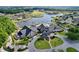Aerial view of a grand clubhouse, showcasing beautifully landscaped grounds and a lake backdrop at 10309 Marchmont Ct, Tampa, FL 33626