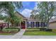 Charming home featuring a red door, dormer windows, and professionally landscaped yard at 10309 Marchmont Ct, Tampa, FL 33626