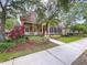 Charming two-story home featuring a cozy front porch, manicured landscaping, and a vibrant red front door at 10309 Marchmont Ct, Tampa, FL 33626