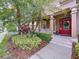 Inviting front entrance with a bright red door, columns, and lush landscaping at 10309 Marchmont Ct, Tampa, FL 33626