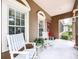 Cozy front porch with white rocking chairs, plants, and a view of the front yard at 10309 Marchmont Ct, Tampa, FL 33626