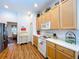 Cozy kitchen featuring wood floors, lighter colored cabinets, and white appliances at 10309 Marchmont Ct, Tampa, FL 33626