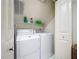 Efficient laundry room equipped with modern washer and dryer units, plus storage shelf at 10309 Marchmont Ct, Tampa, FL 33626