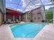 Backyard pool features a screen enclosure, red umbrella, and plenty of space for relaxing at 10309 Marchmont Ct, Tampa, FL 33626