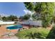 Backyard featuring a refreshing pool, complimented by a well-manicured lawn and privacy fence with an abundance of shrubs and colorful flowers at 1041 Persimmon Dr, Palm Harbor, FL 34683
