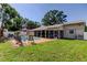 Beautiful backyard with a refreshing pool, enhanced by manicured lawn areas, thoughtful landscaping, and a charming outdoor living space at 1041 Persimmon Dr, Palm Harbor, FL 34683