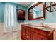 Bathroom features dual sink vanity, custom mirror, wood cabinet, and stylish fixtures at 1041 Persimmon Dr, Palm Harbor, FL 34683