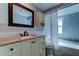 Elegant bathroom with a granite countertop, cream cabinets, and a shower-tub combination at 1041 Persimmon Dr, Palm Harbor, FL 34683