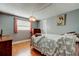 Comfortable bedroom featuring wood floors, natural light, and soothing gray walls at 1041 Persimmon Dr, Palm Harbor, FL 34683