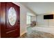 View of the wood front door with decorative oval glass and spacious living room beyond at 1041 Persimmon Dr, Palm Harbor, FL 34683