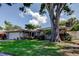 Charming single-story home boasts a lush lawn, mature trees, and a two-car garage at 1041 Persimmon Dr, Palm Harbor, FL 34683