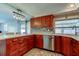 Kitchen with wood cabinetry, stainless steel appliances, and ample countertop space at 1041 Persimmon Dr, Palm Harbor, FL 34683