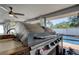 View of outdoor grill with pool in background on outdoor patio at 1041 Persimmon Dr, Palm Harbor, FL 34683
