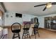 Outdoor kitchen featuring a counter bar, refrigerator, and a ceiling fan on the patio at 1041 Persimmon Dr, Palm Harbor, FL 34683