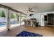 Outdoor kitchen features an outdoor bar, grill, mini fridge, and a view of the pool at 1041 Persimmon Dr, Palm Harbor, FL 34683