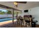 Outdoor kitchen featuring a counter bar, ceiling fan, and view of the pool on the patio at 1041 Persimmon Dr, Palm Harbor, FL 34683
