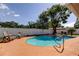 Sparkling pool featuring a spacious patio, surrounded by a privacy fence and lush landscaping creating a serene backyard oasis at 1041 Persimmon Dr, Palm Harbor, FL 34683