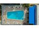 Aerial view of the community pool surrounded by lounge chairs and the community buildings at 1115 Rue Des Chateaux # 2B, South Pasadena, FL 33707