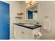 This bathroom features a single sink vanity and decorative shelving for storage at 1115 Rue Des Chateaux # 2B, South Pasadena, FL 33707