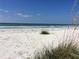 Beautiful white sand beach with gentle waves and clear blue skies at 1115 Rue Des Chateaux # 2B, South Pasadena, FL 33707
