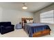 Bedroom with natural light, woven wood furniture, and decorative blue accent chair at 1115 Rue Des Chateaux # 2B, South Pasadena, FL 33707